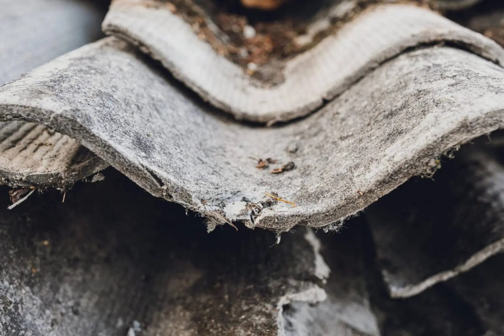 Here's an alt tag for the image: Old, weathered, asbestos roof tiles.