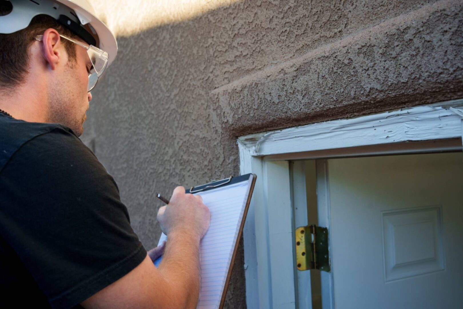 Inspector taking notes on a door frame.