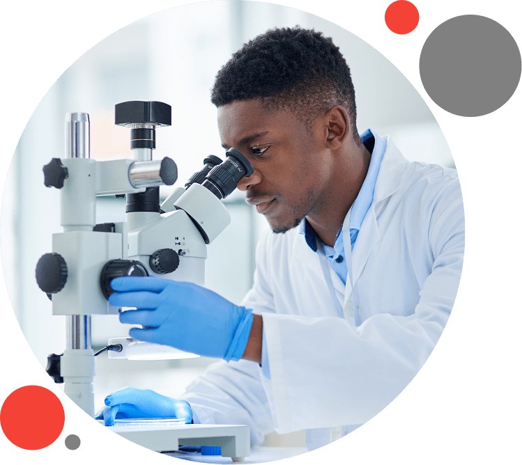 11 A man in lab coat looking through microscope.