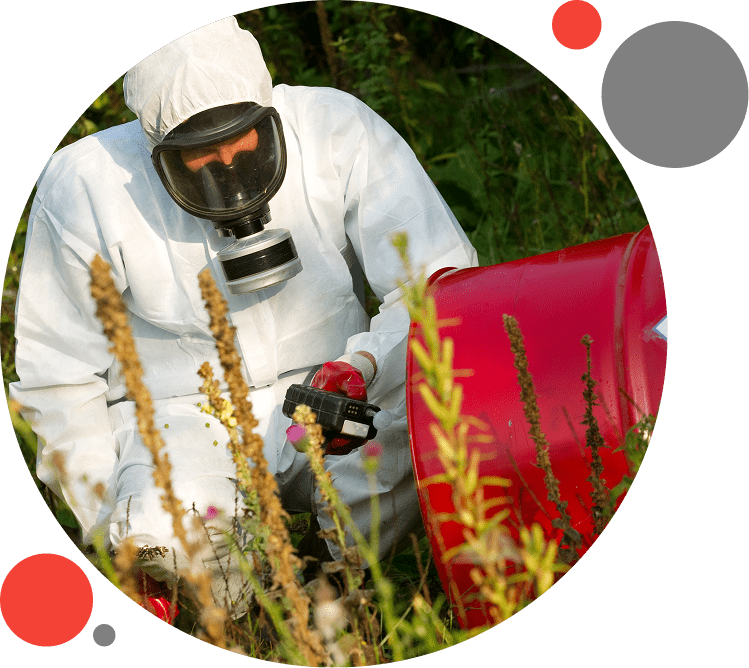 A man in white suit and mask spraying pesticides.