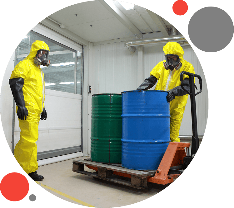 Two people in yellow suits loading barrels on a dolly.
