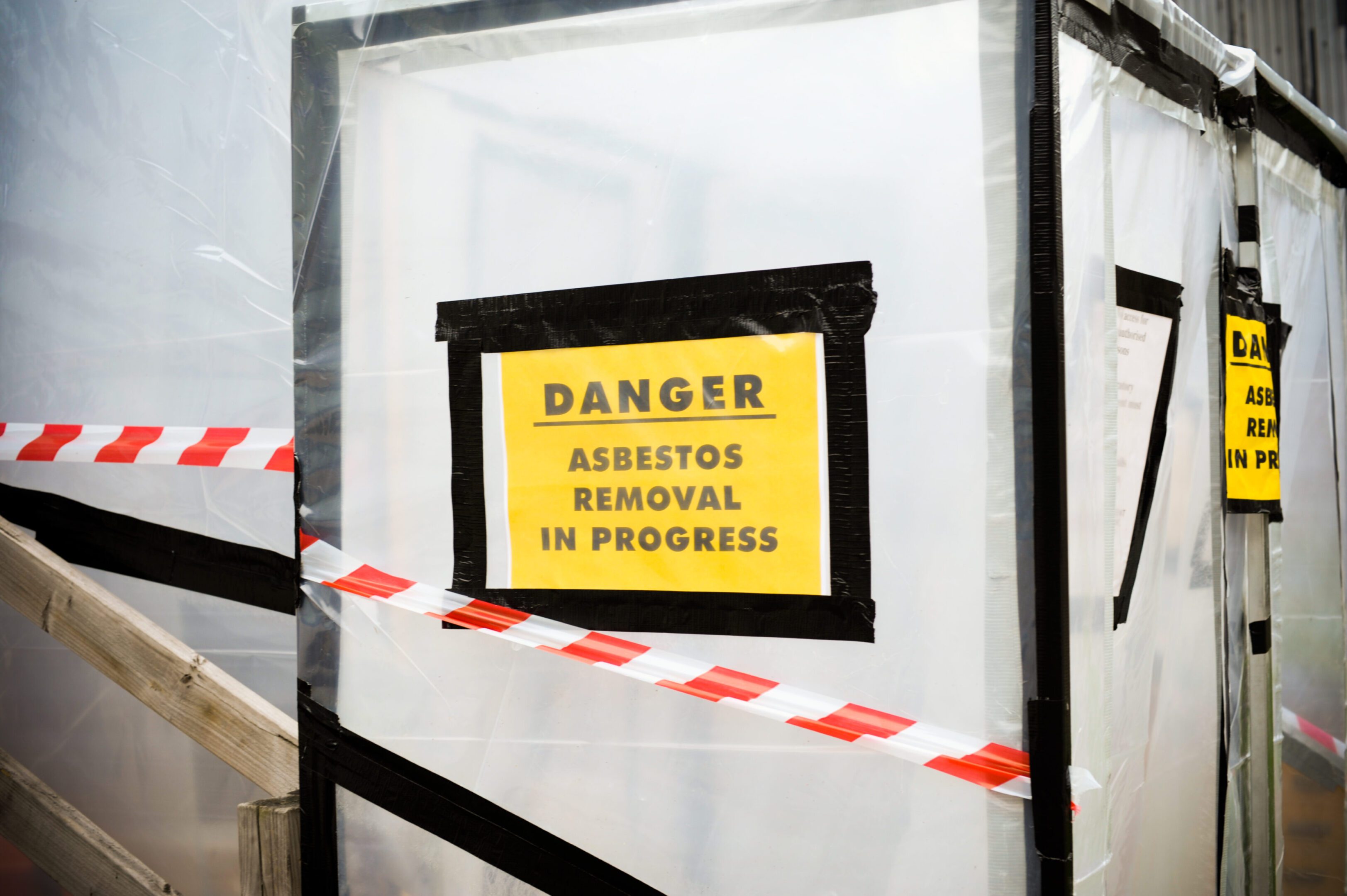 A sign warning of asbestos in progress.